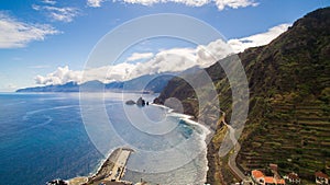 Coastal road with steep coast and beautiful blue ocean sky, Madeira, Portugal