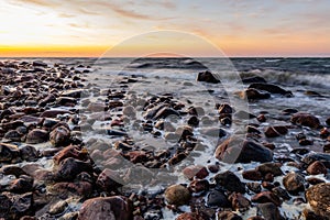 Coastal rocks and motion of ripples at sundown