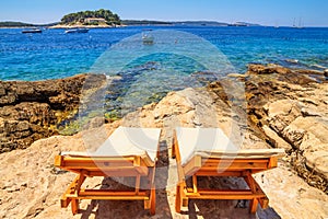 Coastal summer landscape - view of the beach loungers on a rocky seashore, on the island of Hvar