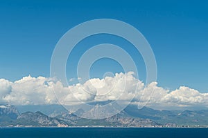 A coastal town at the foot of the mountains and the sea. Clouds in the mountains