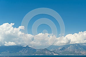 A coastal town at the foot of the mountains and the sea. Clouds in the mountains