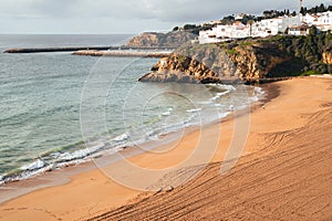 Coastal view of Albuferia in the Algarve region of Portgual, showing the beach, cliffs and jetty