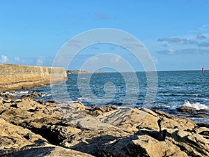 Coastal View of Quiberon, Morbihan with Ancient Stone Wall, Rocky Beach, and Dynamic Ocean Waves photo