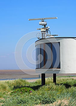 Coastguard station in fleetwood with radar antennae with crass covered dunes leading to the beach on a summers day in brig