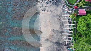 Coastline of Amed, Bali. Beach with stones and fishing boats. Aerial view.