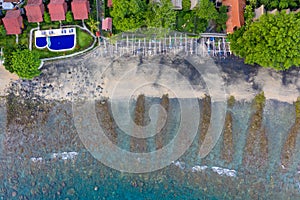 Coastline of Amed, Bali. Beach with stones and fishing boats. Aerial view. photo