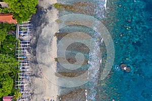 Coastline of Amed, Bali. Beach with stones and fishing boats. Aerial view. photo