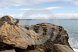 Coastline with big rocks and blue sea on background, Auckland, New Zealand