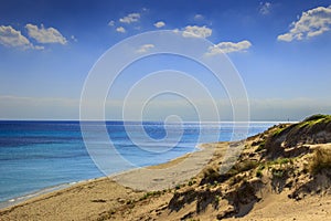 Summer seascape,Apulia coast: Marina di Lizzano beach Taranto. In the foreground dunes with lush mediterranean scrub. photo