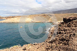 Coastline with cliffs and Atlantic Ocean near beach Playa de los Morteros on Canary Island Tenerife, Spain photo