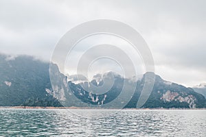 Coastline with cloudy sunset sky, sea and mountains in the Khao Sok National Park, Suratthani Thailand.