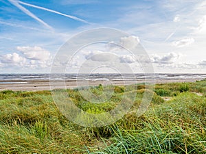 Coastline with dunes, beach and boat dried out on sand flats of