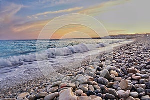 The coastline is filled with rocks and blue waves at sunset