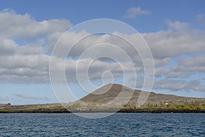 Coastline of  Floreana Island with a tourist area marker, Galapagos Islands