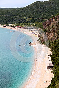 Coastline with Jaz beach in Budva municipality in Montenegro. Parasols with sun beds are on Adriatic sea shore