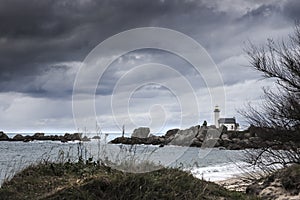 Coastline landscape in low tide with lighthouse and peculiar rocks in Brittany, France