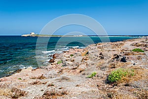The coastline near Portopalo (Sicily), and the island of Capo Passero in the background photo