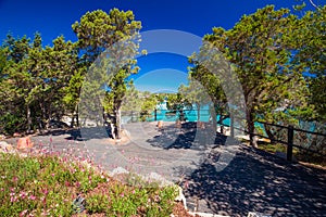 Coastline promenade with pine trees and tourquise clear water at Porto Cervo, Costa Smeralda, Sardinia, Italy