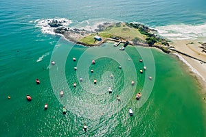 Coastline with rocky island, beach and ocean with waves. Aerial view of Ponta das Campanhas in Floripa