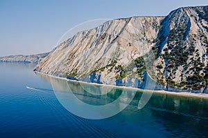 Coastline with sea and highest cliff with pine trees. Summer day on sea and boat. Aerial view