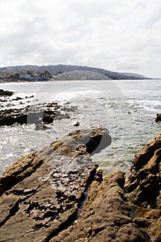 Coastline view from a rocky ledge of California beaches. Vacation destinations.