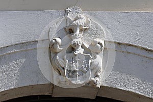 A coat of arms above the archway of an old house