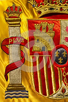 Coat of arms of Spain nation richly embroidered on its flag photo