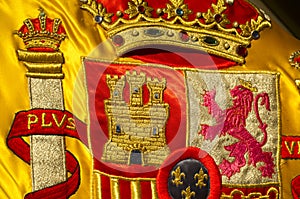 Coat of arms of Spain nation richly embroidered on its flag photo