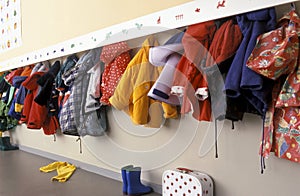 Coat rack in a nursery with a lot of chidren coats photo