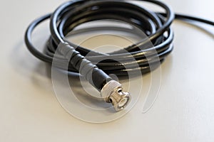 Coaxial tv cable is wound into a skein close-up on a wooden background