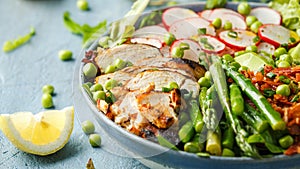 Cobb salad bowl with grilled chicken breast, asparagus, avocado, radishes and bacon