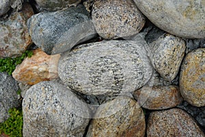 Cobble of gneiss metamorphic stones on the rock wall.