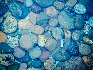 Cobble stones under blue water