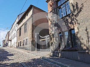 A cobbled, narrow, ancient street of the city of Vyborg on a sunny summer day