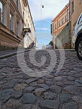 A cobbled, narrow, ancient street of the city of Vyborg on a sunny summer day