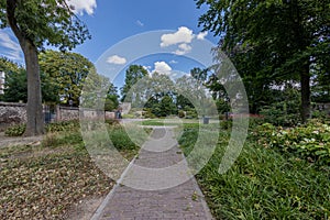 Cobbled pedestrian sidewalk between green grass in the Isabelle garden