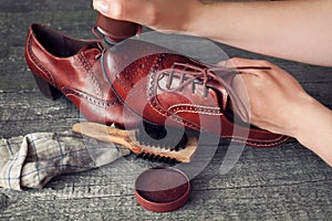 Cobbler applying shoe shiner on shoe photo