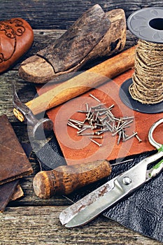 Cobbler's tools on a wooden background