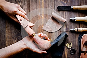 Cobbler with tools work process dark background top view