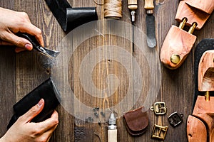 Cobbler with tools work process dark background top view