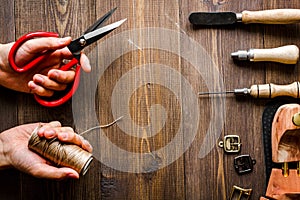 Cobbler with tools work process dark background top view