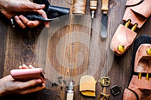 Cobbler with tools work process dark background top view