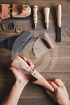 Cobbler with tools work process dark background top view