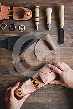 Cobbler with tools work process dark background top view