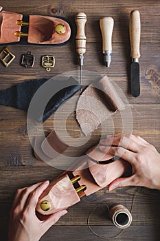 Cobbler with tools work process dark background top view