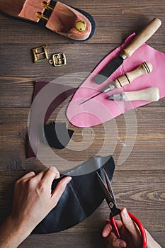 Cobbler with tools work process dark background top view