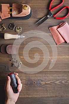 Cobbler with tools work process dark background top view