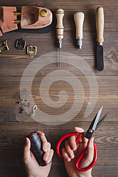 Cobbler with tools work process dark background top view