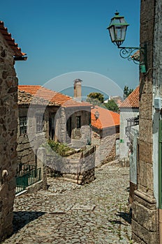 Cobblestone alley on slope and stone old houses