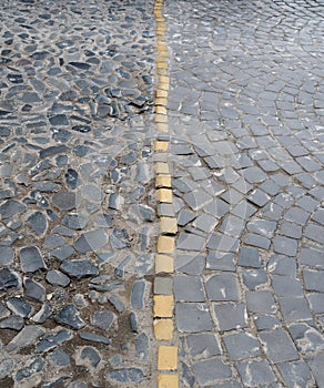 Cobblestone pavement with yellow dividing line